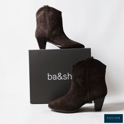 une paire de bottines en daim marron posée sur une boîte