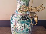 a vase that has a lamp on it on a table