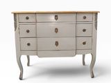 a white dresser with four drawers and a wooden top