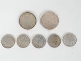 a close up of a number of coins on a white surface