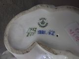 a white porcelain figurine with a green and red design on it