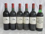 six bouteilles de vin sont alignées sur une table