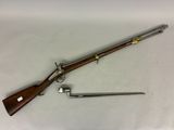 un fusil muni d'une crosse en bois et d'une poignée métallique sur un fond blanc
