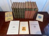several books are sitting on a table next to a stack of books