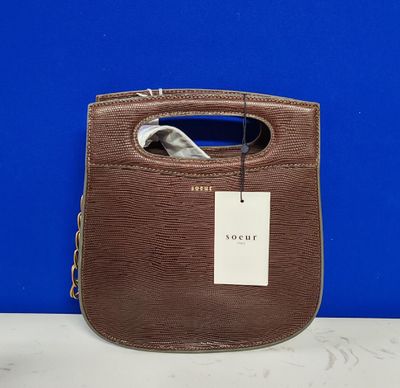 une photo d'un sac à main marron sur lequel est accrochée une étiquette