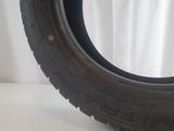 a tire on a white surface with a white curtain behind it