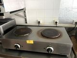a stove top with two burners on it in a kitchen