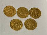 four gold coins sitting on top of a piece of paper