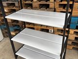 a black and white shelving with three shelves in front of pallets