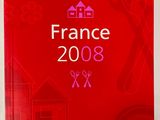 un livre rouge sur lequel figure l'image d'un bâtiment