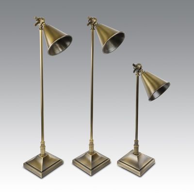 a set of three brass lamps on a stand
