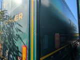 a green train car that is parked on the side of the road