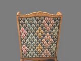 a chair with a colorful upholstered back and a wooden frame