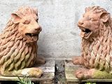 two statues of lions that are sitting on a pallet