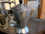 a silver coffee pot sitting on top of a metal box