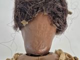 a doll that is sitting on a table with a bird on top of it