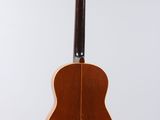 an acoustic guitar hanging from the back of a white wall