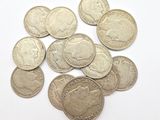some silver coins sitting on top of each other on a white surface