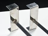 two metal spoons that are on a white table
