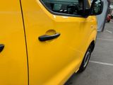 a yellow van parked in a parking lot next to a building