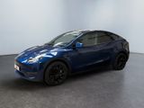 un SUV Tesla bleu garé dans une pièce blanche