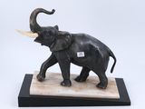 statue d'un éléphant avec des défenses, posée sur un socle en marbre