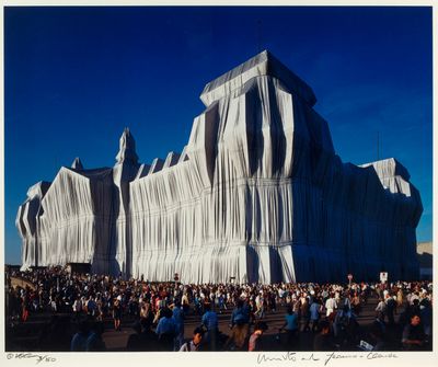 an image of a large group of people standing in front of a building covered in fabric