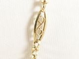 gold plated necklace with a leaf charm on a white background