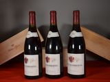 three bottles of wine sit on a table next to a wooden box