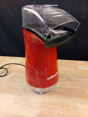 un mixeur rouge posé sur une table en bois