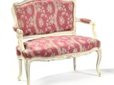 a pink and white chair with a floral upholstered back