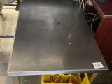 une table en métal devant laquelle se trouve une poubelle jaune