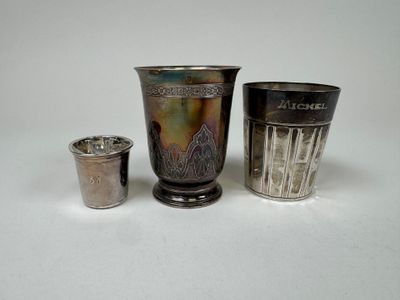 three silver cups sitting next to each other on a table