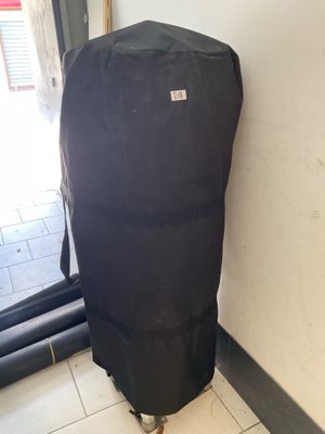 a large black bag sitting on top of a rolling suitcase