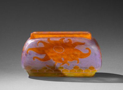 un vase orange et violet posé sur une table blanche