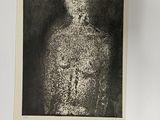 a black and white photo of a man with a skull on his chest