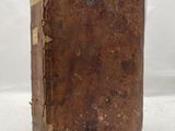 an old book that is sitting on a white surface