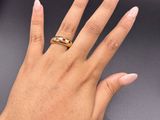 woman ' s hand with pink manicured nails and a gold ring