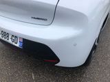 the rear end of a white car parked in a parking lot
