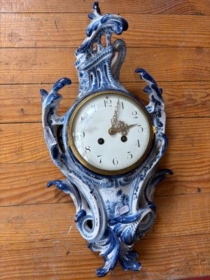 une horloge bleue et blanche accrochée à un mur en bois