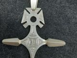 un gros plan d'une croix en argent sur une surface noire