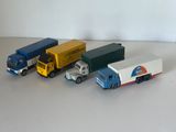 quatre camions miniatures alignés sur une table