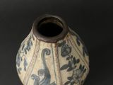 a blue and white vase sitting on a black surface