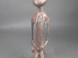 une vieille figurine en bronze représentant un homme avec un oiseau sur la tête