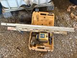 une boîte à outils posée par terre, contenant une règle et d'autres outils