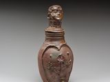 une image représentant un vase marron orné d'un visage