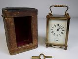 a small clock sitting next to a box with a key in it