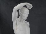 a white sculpture of a man holding his head in his hands