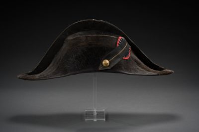 a black hat with a red ribbon on top of a clear base