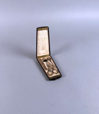 une petite boîte en argent sur laquelle est représenté un homme